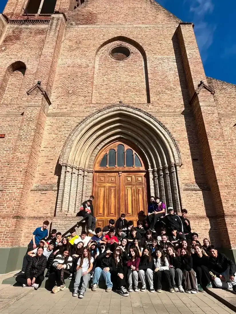 Los jóvenes en la escalinata del templo, frente a la fachada de ladrillo