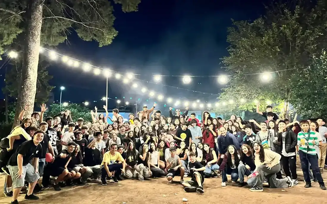 La Juntada reunida de noche bajo las guirnaldas de luces