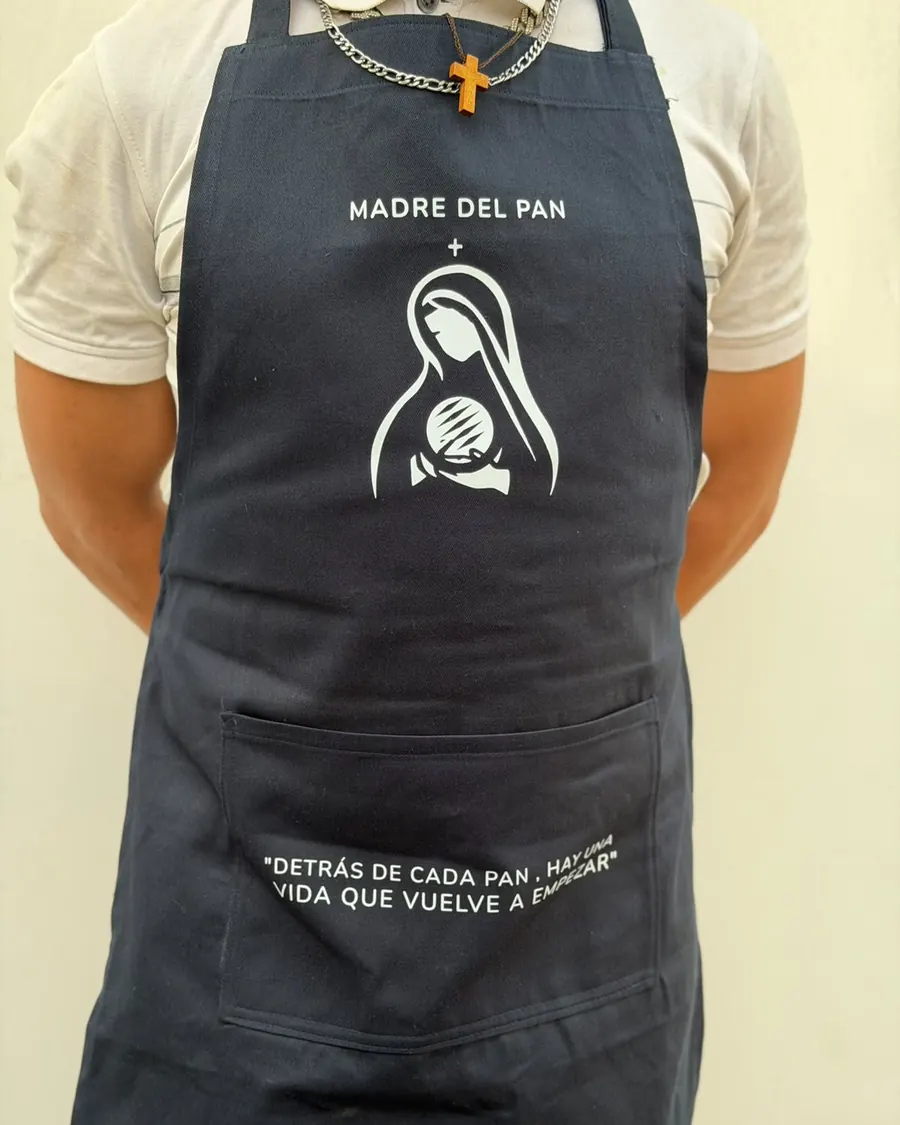 Delantal de la Panadería Madre del Pan con el logo y la frase: detrás de cada pan, hay una vida que vuelve a empezar