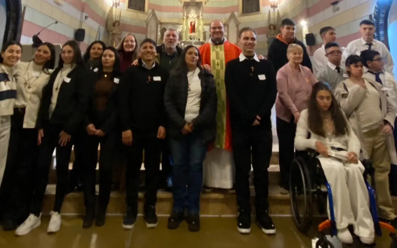 El grupo de adultos y alumnos que recibieron los sacramentos, junto al párroco frente al altar